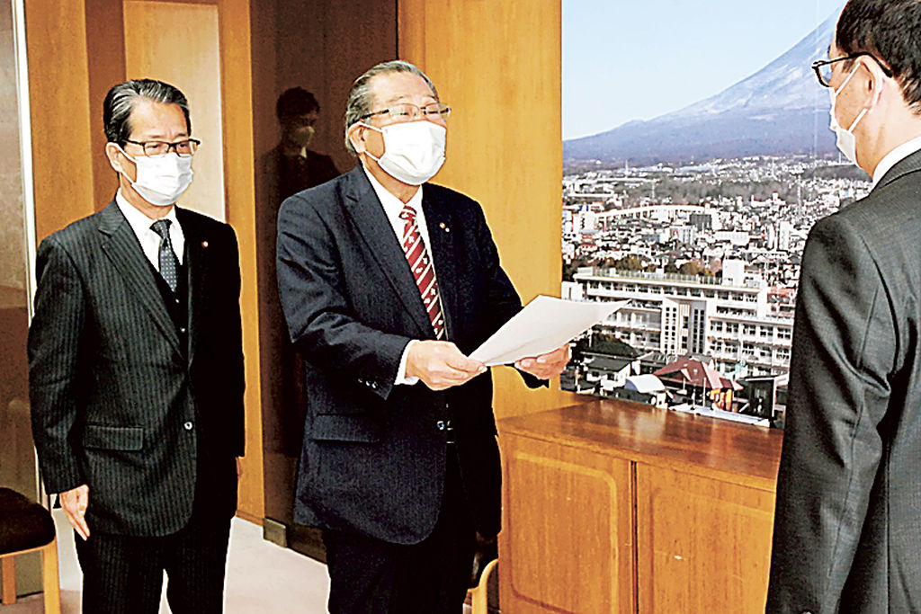 小長井市長（右）に答申を提出する増田会長（中央）ら＝富士市役所