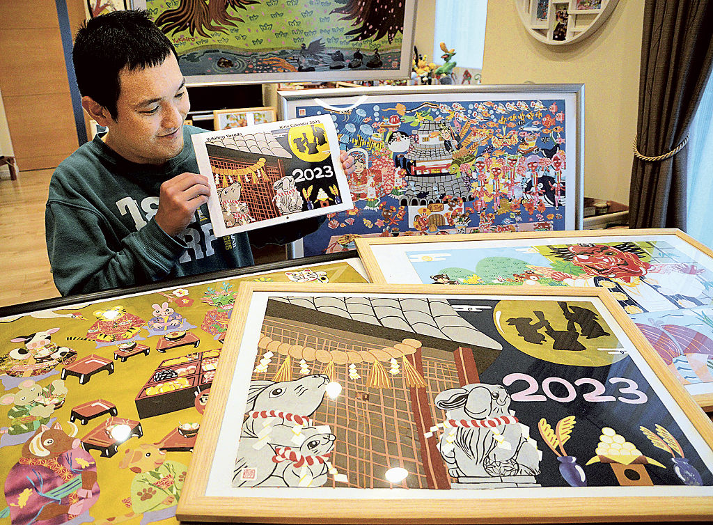 切り絵の原画を前に、２０２３年のカレンダーを紹介する安田さん＝湖西市南台