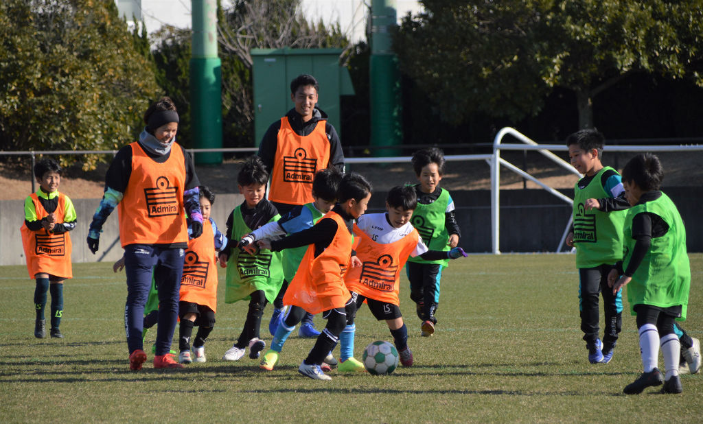 楽しみながらサッカーの基本を学ぶ子どもたち＝磐田市南平松の竜洋スポーツ公園