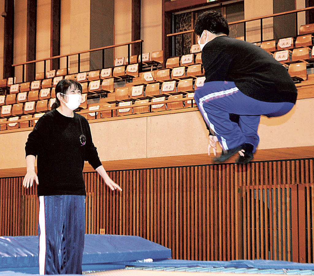 障害がある子どもたちにトランポリンを指導する堀由希子さん（左）＝２０２２年１２月上旬、藤枝市の県武道館