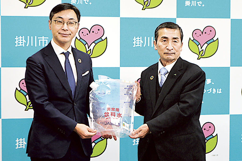 久保田市長（左）に飲料水袋を手渡す松永組合長＝掛川市役所