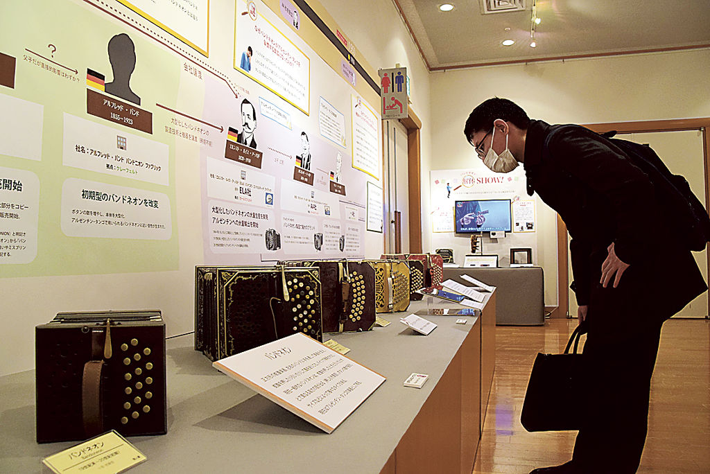 バンドネオンの歴史を紹介するパネルなどが並ぶ企画展＝浜松市中区の市楽器博物館