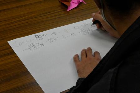「絵しりとり」で絵を描く男性＝２２年１１月、高松市