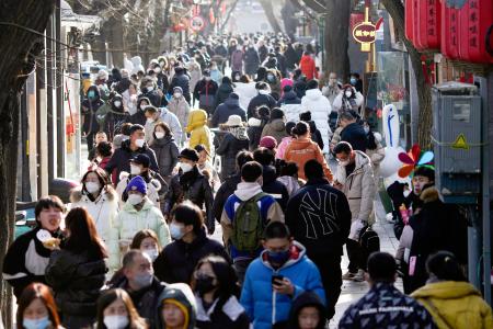 北京市内の繁華街を歩く人たち＝１７日（共同）