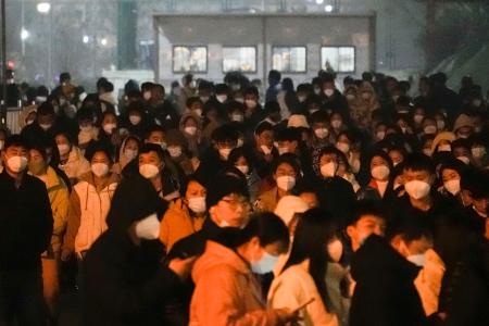 富士康科技集団の工場から出る従業員ら＝１１日、中国河南省鄭州市（共同）