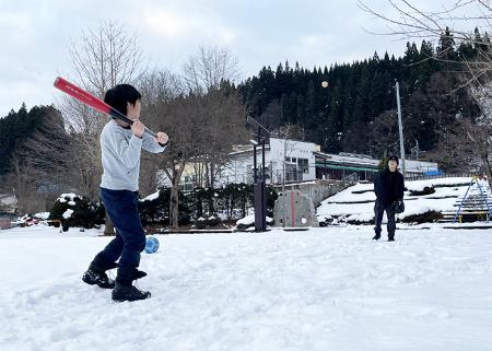 自宅近くで雪遊びする真鍋さんの子どもたち＝２０２２年１２月、秋田県鹿角市