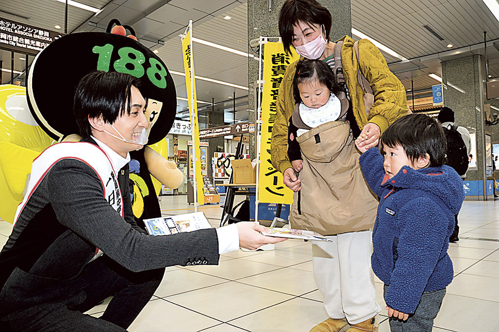 「消費者ホットライン１８８」の啓発グッズを配る帆世さん（左）＝ＪＲ静岡駅