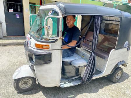 フィリピンのマニラ首都圏で返済間近な三輪タクシーに乗るブンダさん＝２０２２年９月（共同）