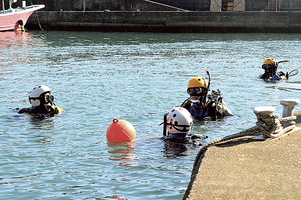 行方不明の太田和子さんの手掛かりを捜索する水難救助部隊員＝２６日午前、熱海市の伊豆山港