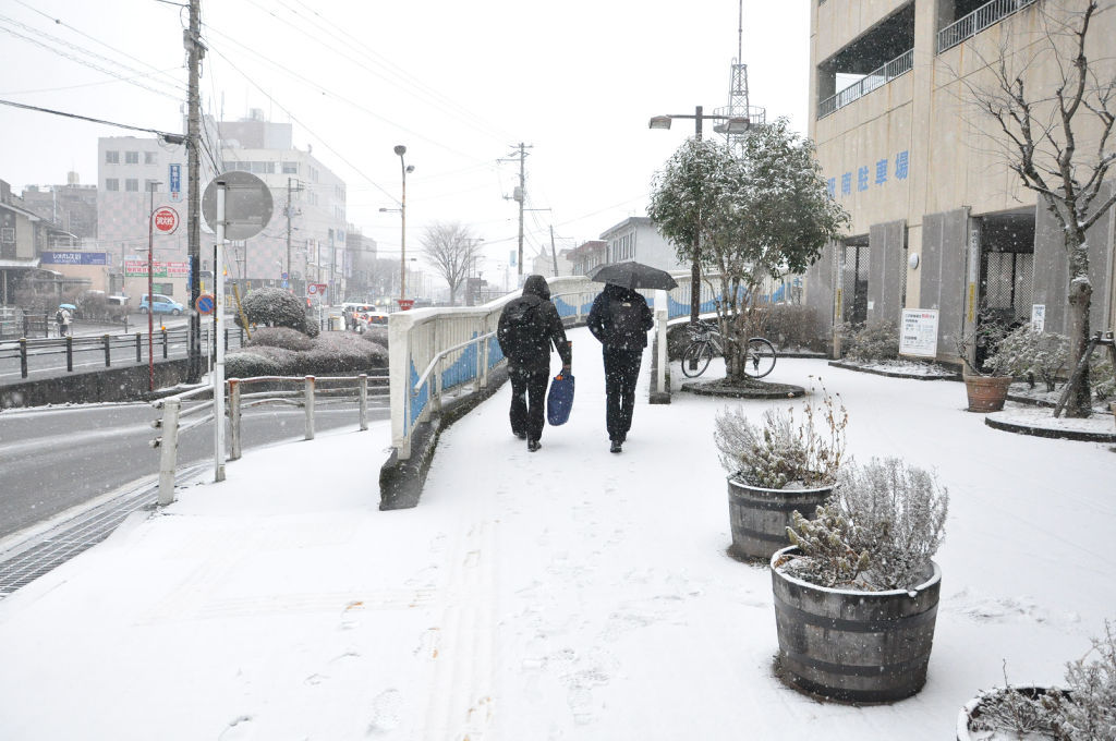 雪が積もった道を歩く人たち＝２７日午後３時４５分ごろ、御殿場市