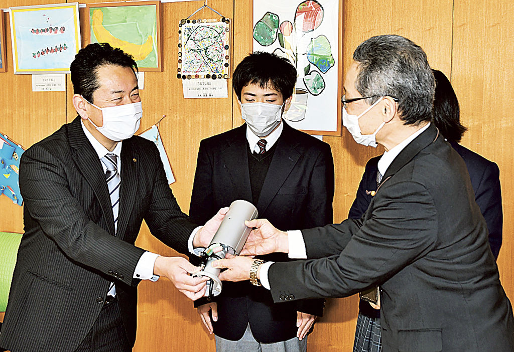 防犯カメラを手渡す鈴木課長（左）＝富士市の富士特別支援学校