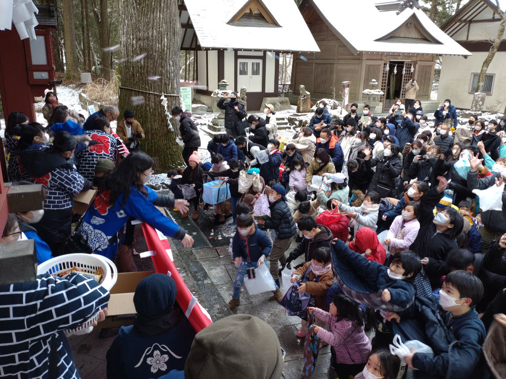まかれた豆や餅をつかみ取る人たち＝小山町須走の冨士浅間神社