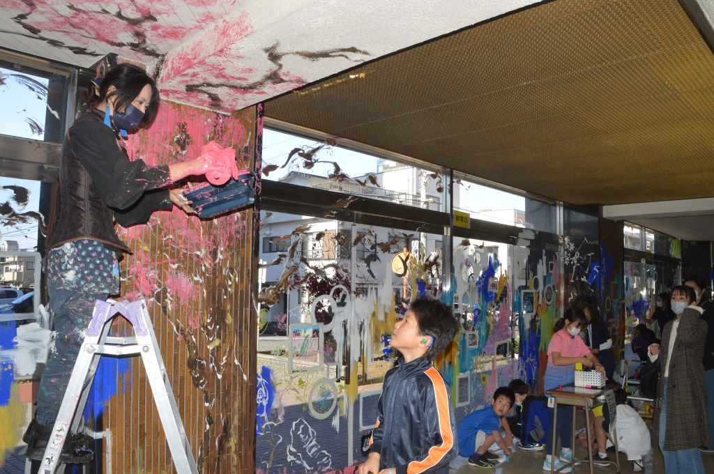 閉館を前に、ロビーに絵を描いたり、メッセージを記すマツナガさん（左）や利用者＝沼津市民体育館