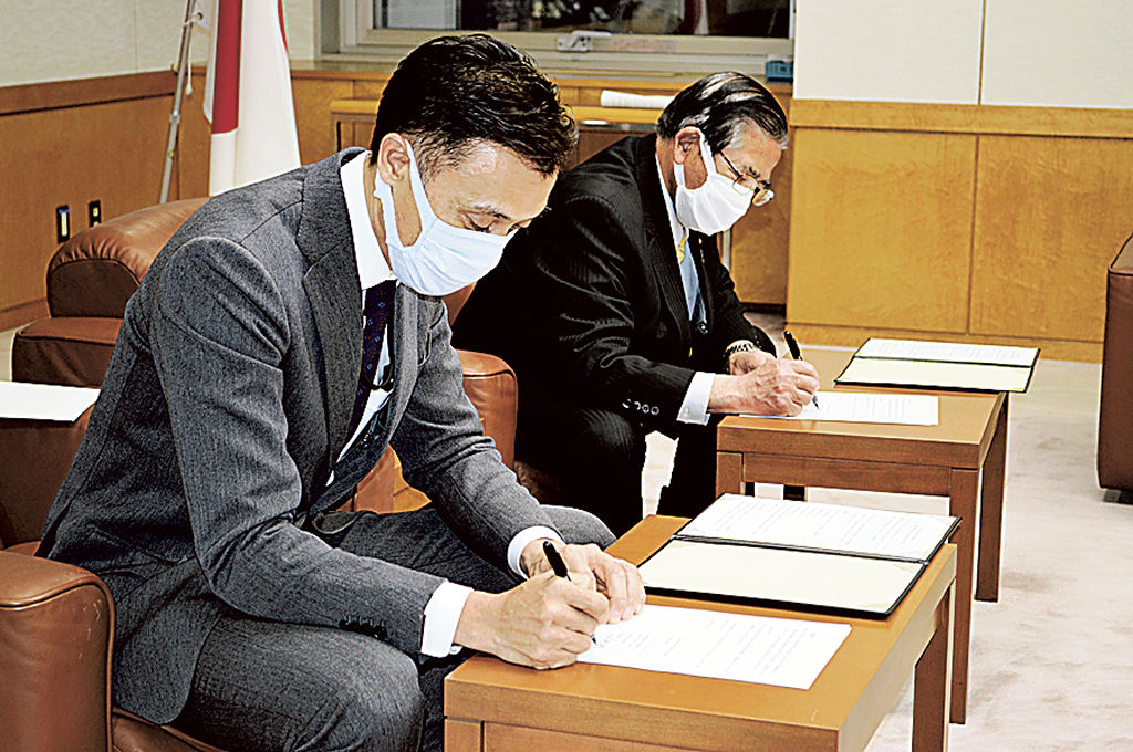協定書に署名する小河路社長（左）と須藤市長＝富士宮市役所