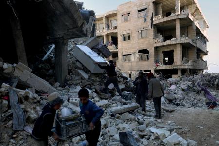 シリア北部アレッポ県で、地震で倒壊した建物から家具を移動させる人たち＝７日（ＡＰ＝共同）