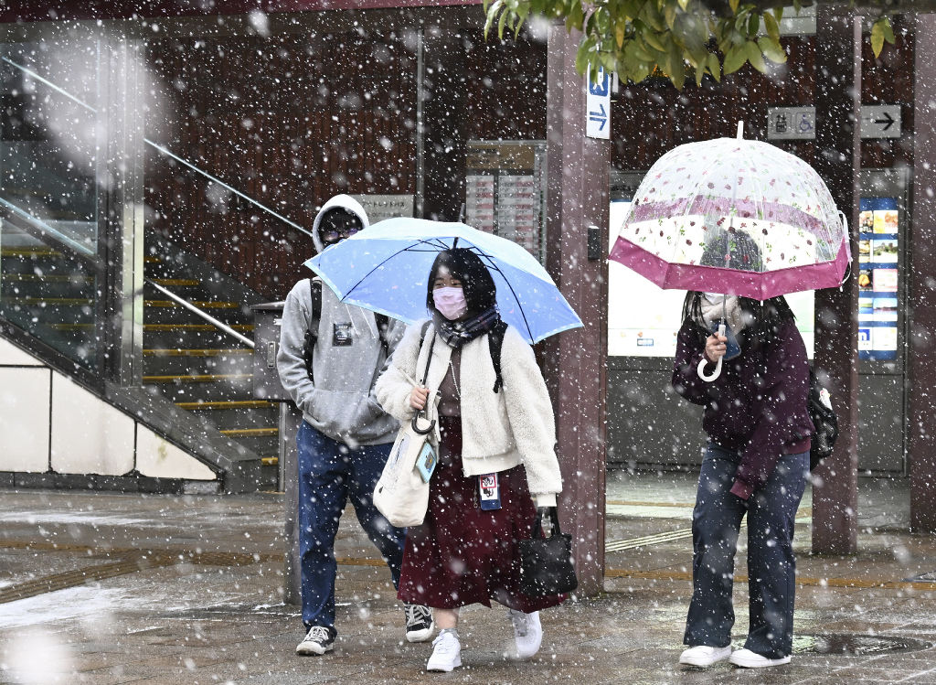 降り始めた雪の中を足早に歩く人たち＝１０日午前８時半ごろ、ＪＲ御殿場駅前（東部総局・山川侑哉）