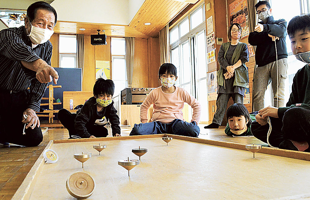 一斉にこまを回し時間を競う児童ら＝静岡市葵区の麻機児童館