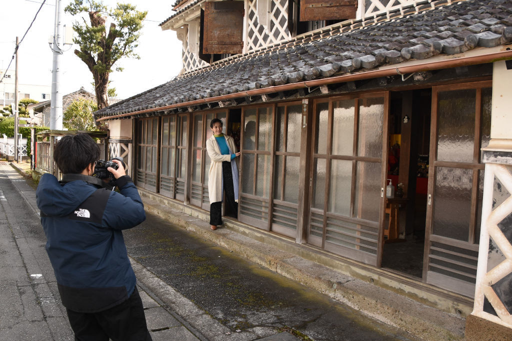 「伊豆文邸」の前で撮影に臨む美村さん＝松崎町松崎