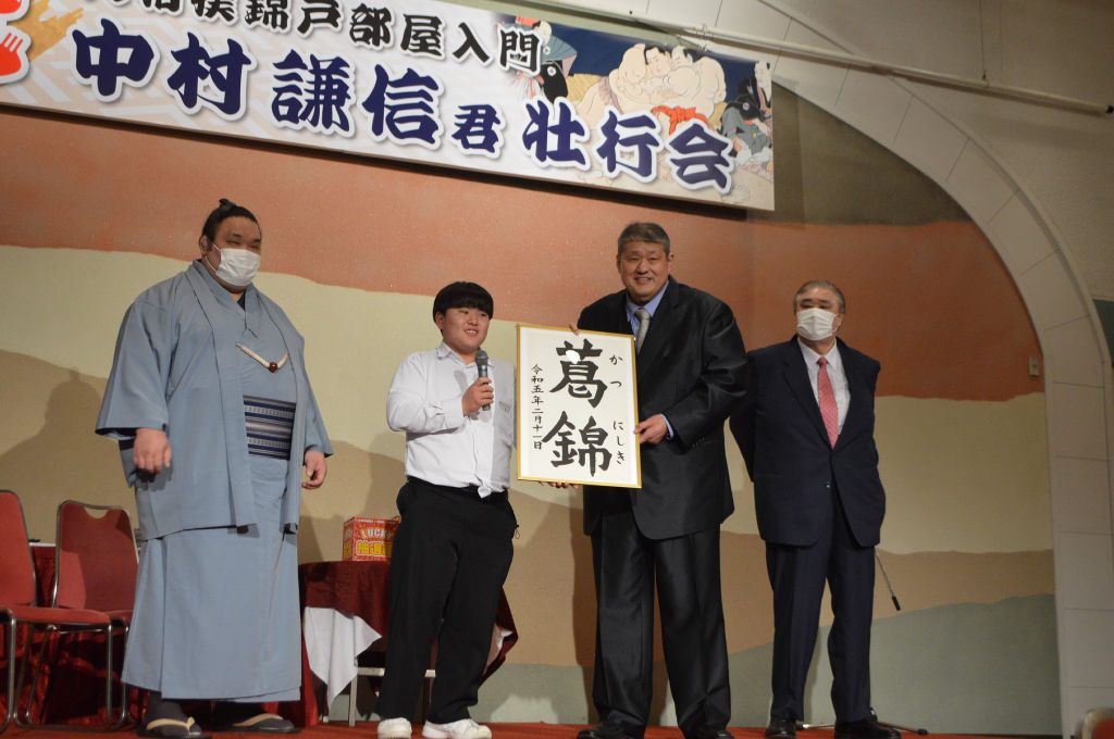 しこ名を発表する中村さん（左から２人目）と錦戸親方（同３人目）＝掛川市内