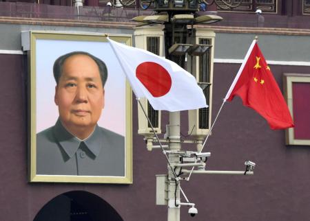 ２０１８年１０月、安倍首相の公式訪問を前に北京の天安門広場に掲げられた日の丸。奥は毛沢東の肖像画（共同）