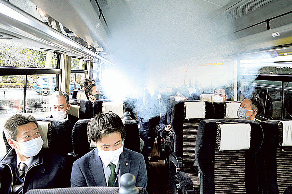 バス車内に充満させた煙を排出する実験を見学する旅行関係者＝２２日、浜松市中区の浜松城公園駐車場