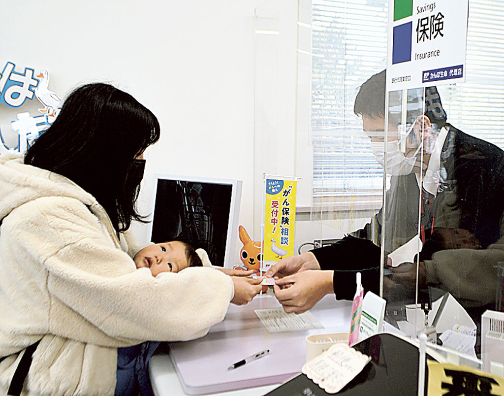 郵便局でマイナンバーカードの手続きを行う利用者（左）＝裾野市の市役所前郵便局
