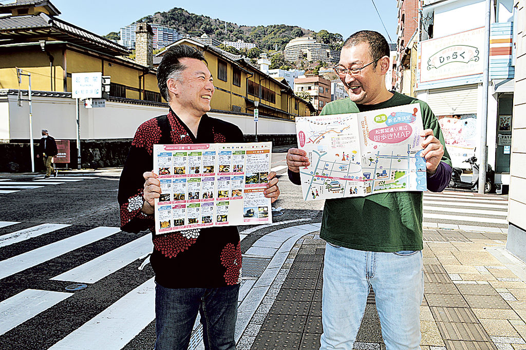 起雲閣通りのマップを手にする鈴木会長（左）ら＝熱海市昭和町