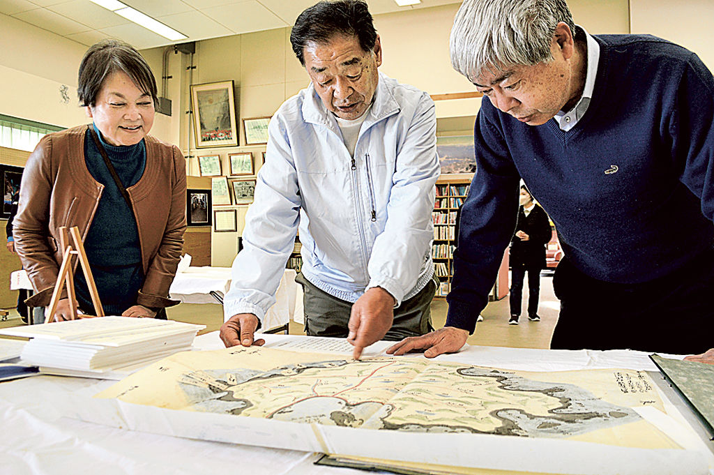 古文書を確認する（左から）斎藤さんと森田さん、塚本さん＝２日午後、下田市の須崎漁民会館