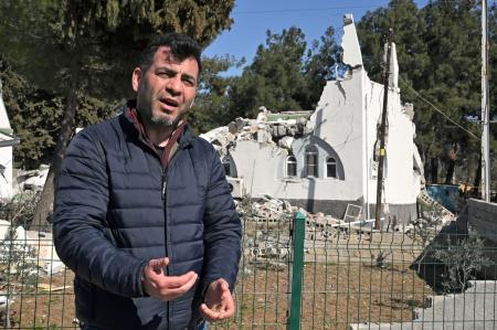 倒壊した建物の前で後悔を語るサルマン・ギョズルギョルさん＝２月１７日、トルコ南部カフラマンマラシュ県（共同）