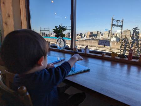 店から新幹線を眺める子ども＝２０２２年１２月２０日、東京都北区