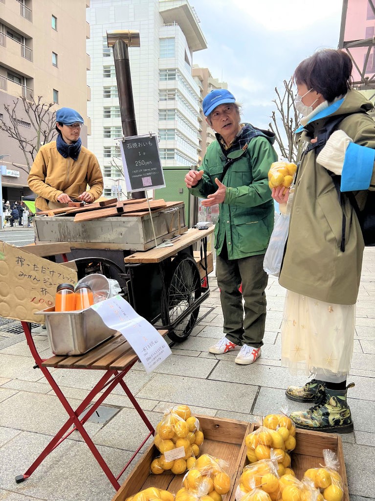 リヤカーで焼き芋を販売する宮崎篤人さん（中央）と後藤師珠馬さん（左）。冬季は地元産みかんも販売する＝２月中旬、沼津市内
