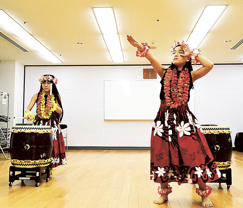 フラダンスと太鼓を披露する北島さん（左）と倉田さん（右）＝浜松市西区の雄踏文化センター