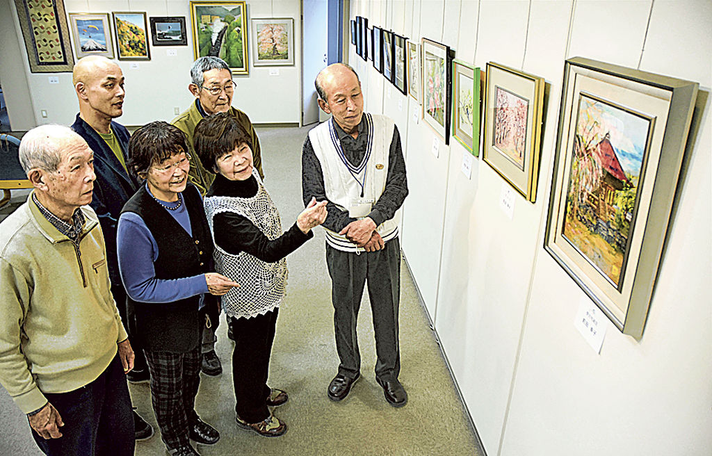 前田さんのちぎり絵作品を鑑賞する息子の和則さん（左から２人目）と同級生ら＝島田市のしずぎんギャラリー四季島田