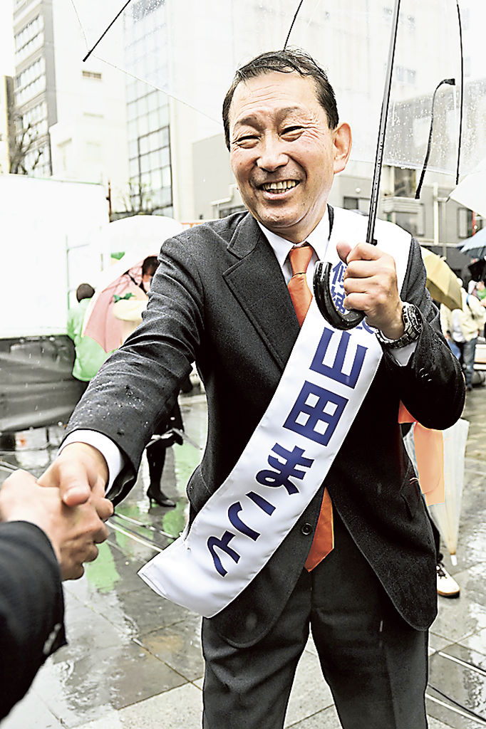 支援者と握手する山田誠候補＝２６日午前、静岡市葵区