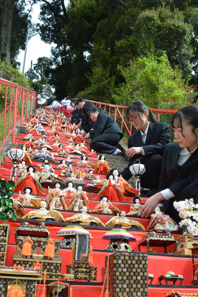 １１８段のひな飾りを展示する高校生ら＝下田市の天神神社
