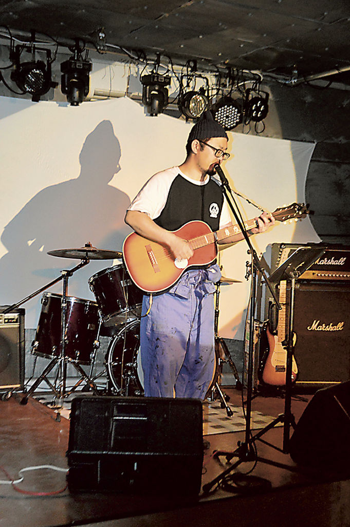 ２階のライブスペースでギターを演奏する寺沢店長