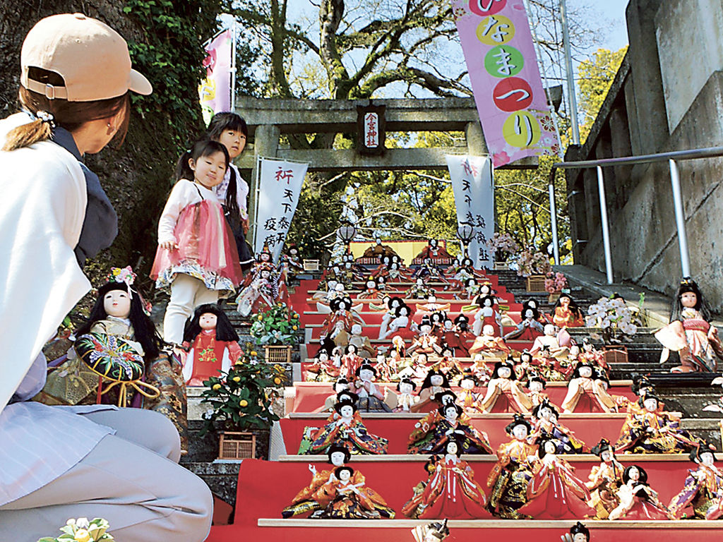 階段に並んだひな人形を見物する親子連れ＝熱海市桜町の今宮神社