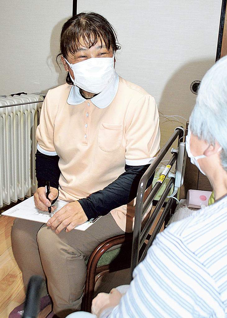 高齢者宅を訪問し、入浴介助などにあたる森田裕美子さん。笑顔でコミュニケーションを取る＝３月下旬、静岡市清水区