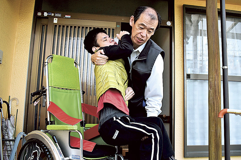 重症心身障害のある息子渡辺隼さん（左）を一人で介護する父裕之さん。緊急時に満床の可能性がある短期入所の現状に不安を抱える＝３月中旬、静岡市清水区