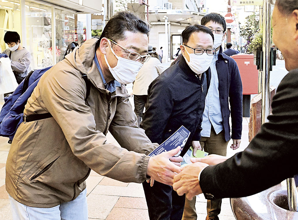 最後の訴えをする候補者（右）と握手する有権者ら＝８日午後、静岡市葵区