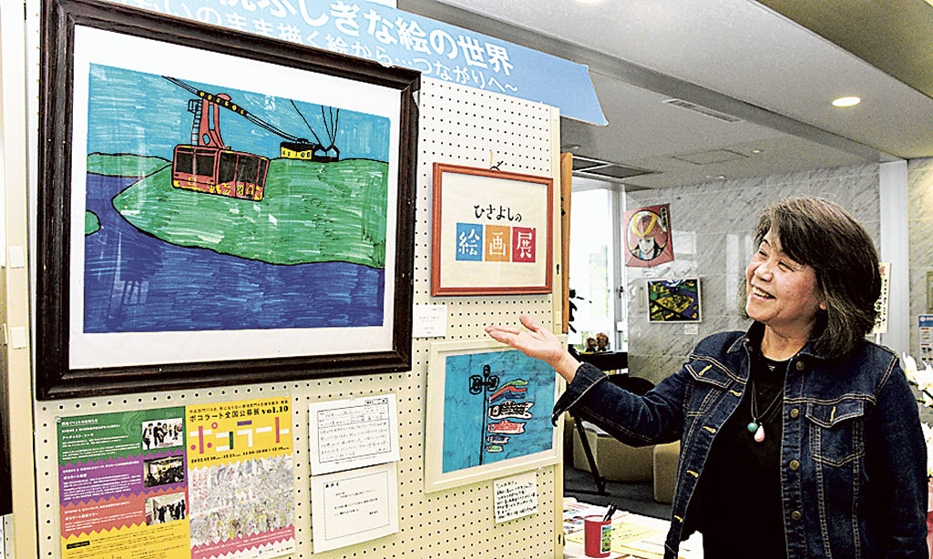 松井久悦さんの絵画作品を紹介する母の照子さん＝浜松市北区細江町の国民宿舎奥浜名湖