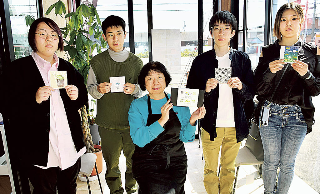 服部代表取締役（中央）と採用作品を製作した学生たち＝焼津市三ケ名のハットリ製茶