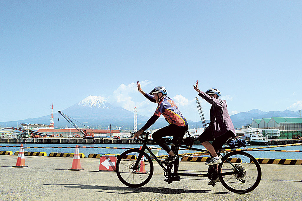 富士山の景観を楽しみながらサイクリングする乗客＝富士市の田子の浦港