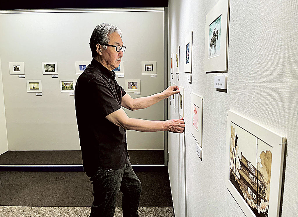 展示作品の位置を調整する画家の山田ケンジさん＝静岡市駿河区の駿府博物館