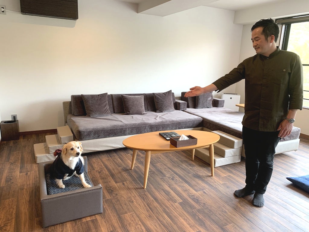 犬と一緒に泊まれる設備を紹介する望月敬太専務＝３月下旬、伊豆の国市長岡の「小松家八の坊」