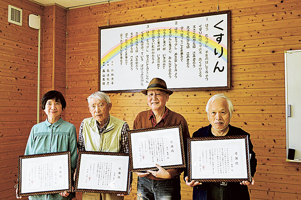 「くすりん」のレリーフが完成し、感謝状が贈られた４人＝菊川市川上の小笠東地区コミュニティセンター
