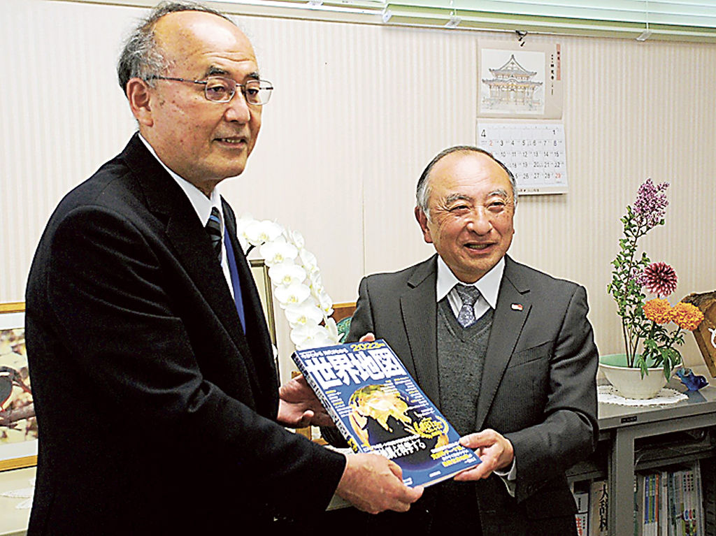 小塚教育長（左）に図書を届けた平出会長＝三島市中央町別館