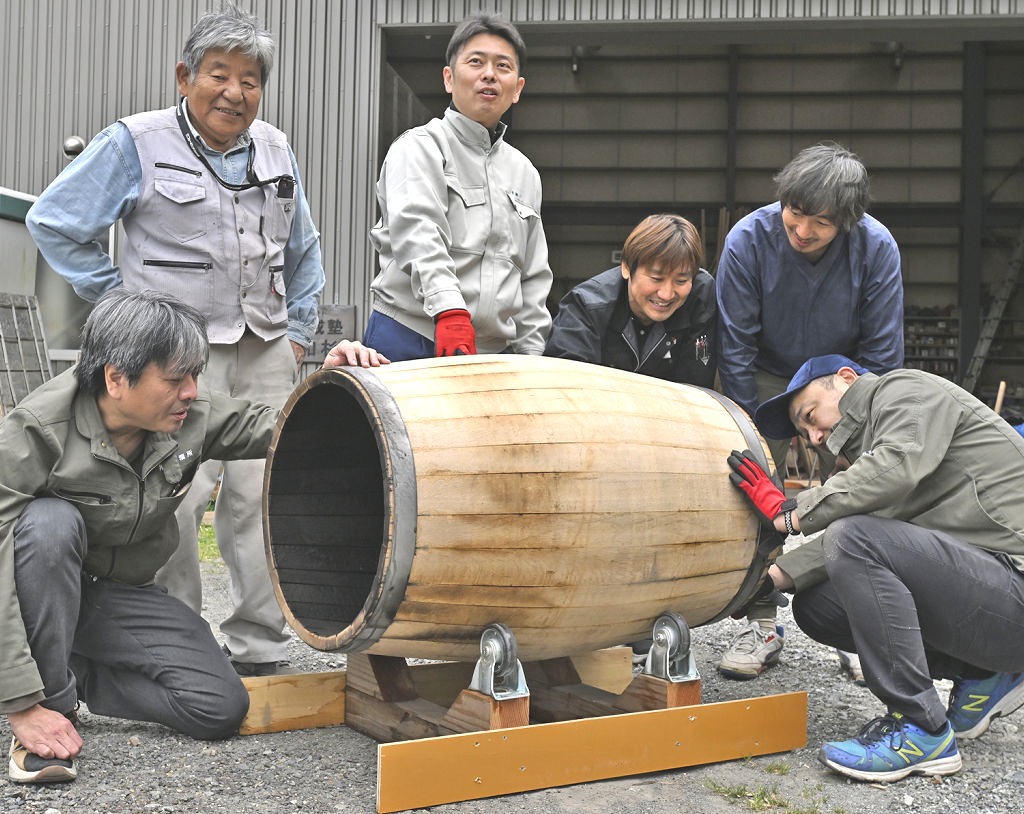 オリジナルのウイスキー熟成用たるを試作した平井岳志さん（左から３人目）や製作に加わったさまざまな業種の職人たち＝４月下旬、静岡市葵区南沼上