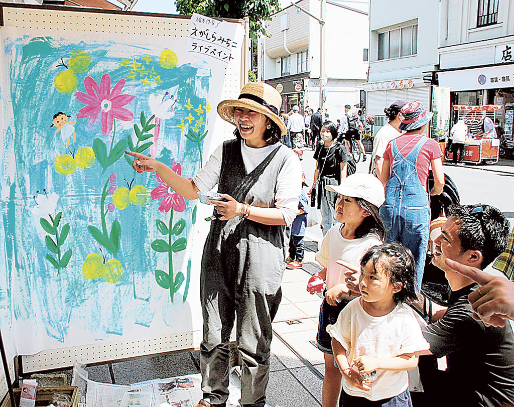 えがしらみちこさん（左）が即興で描くライブペイントを楽しむ子どもたち＝三島市
