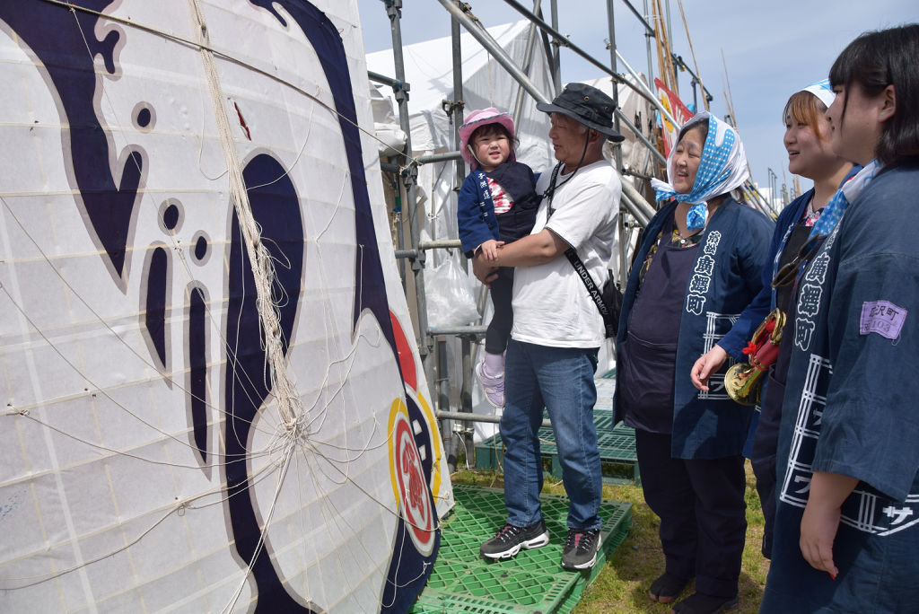 広沢町の凧を眺める中島さん家族＝５日午後、浜松市南区の凧揚げ会場